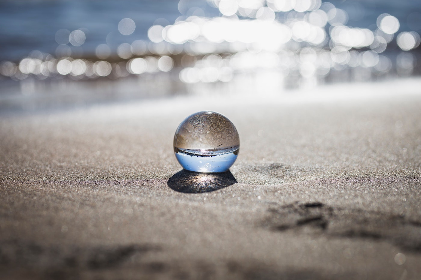 crystal ball sitting on the beach in the sand